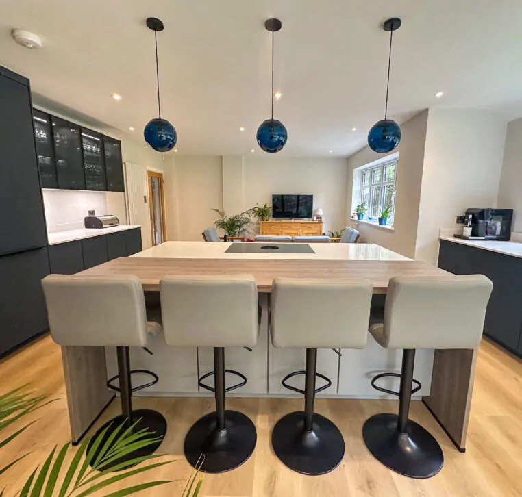Close-up view of the kitchen island in grey and wood with stylish bar stools