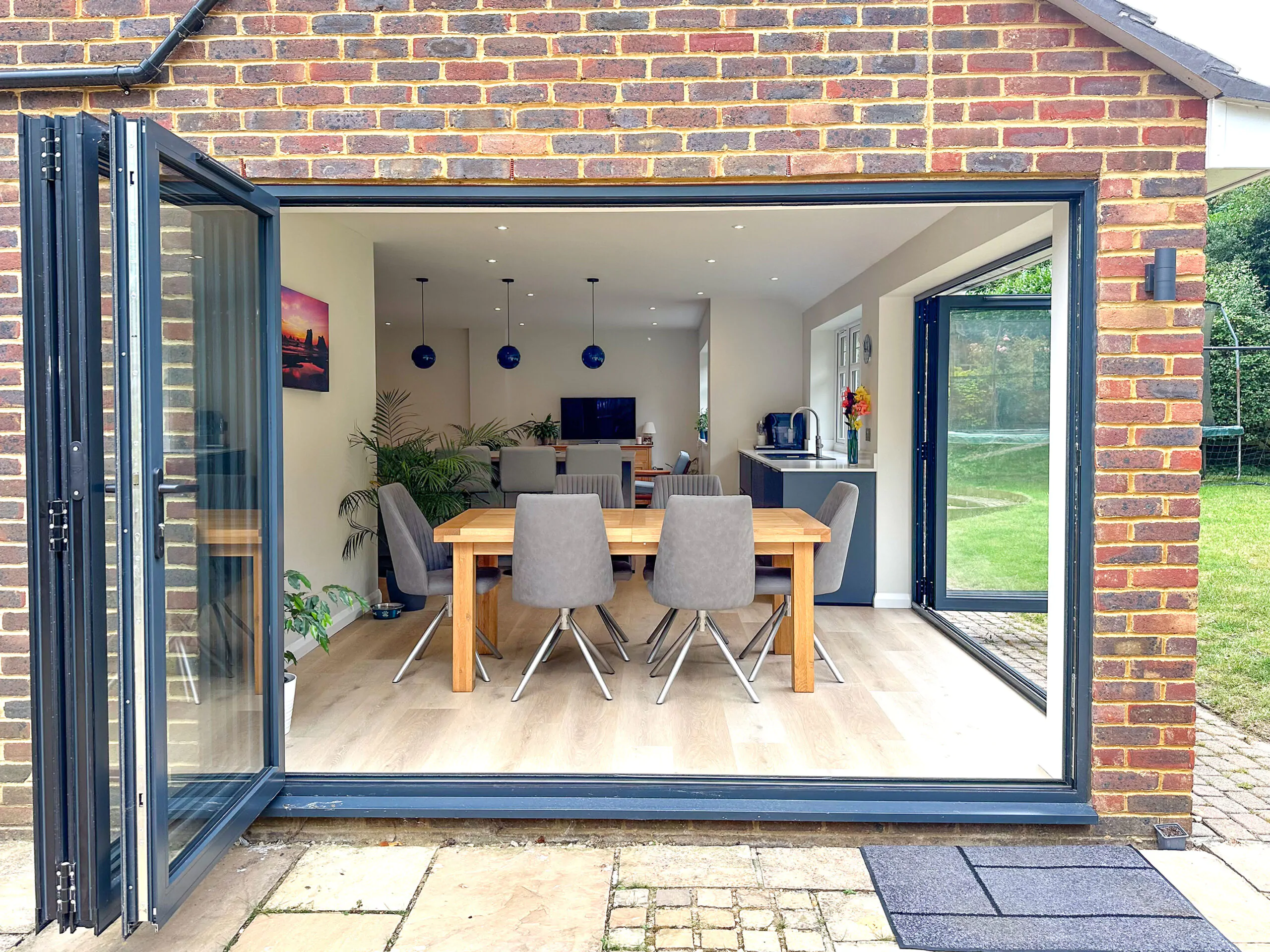 Bifold doors opening to the garden from a modern shaker kitchen with an island