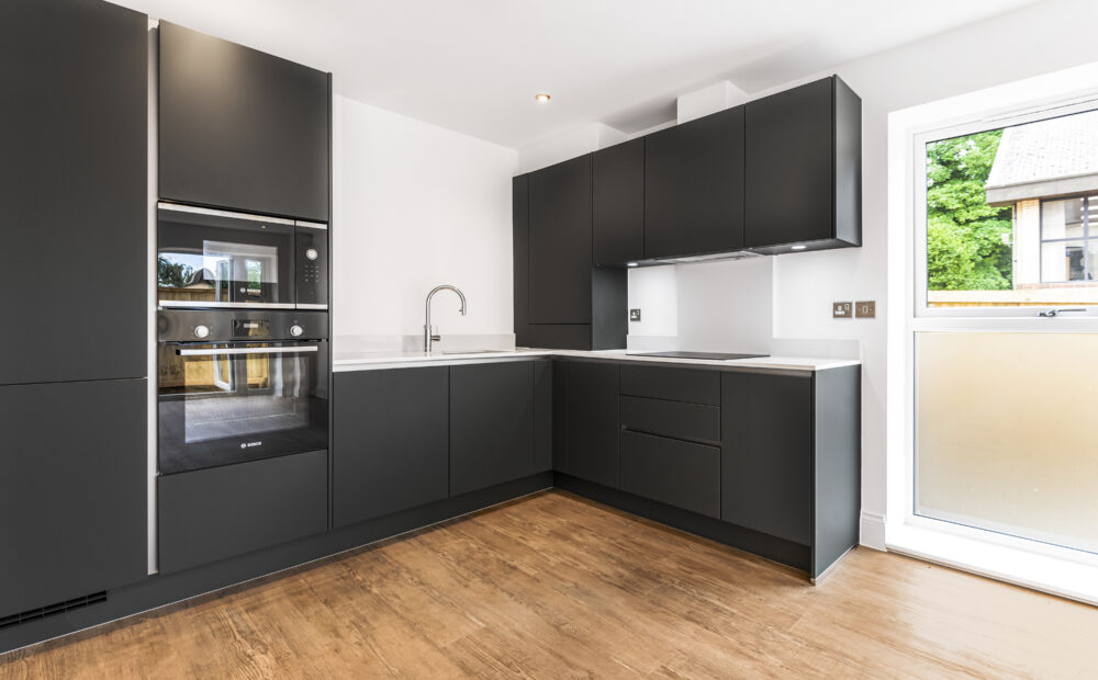 Modern kitchen with L-shaped layout, sleek dark grey cabinets