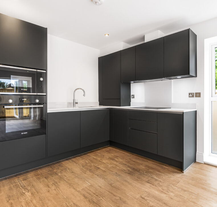 Modern kitchen with L-shaped layout, sleek dark grey cabinets