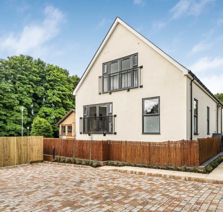 modern residential building in Alton with dual balconies and brick-paved driveway