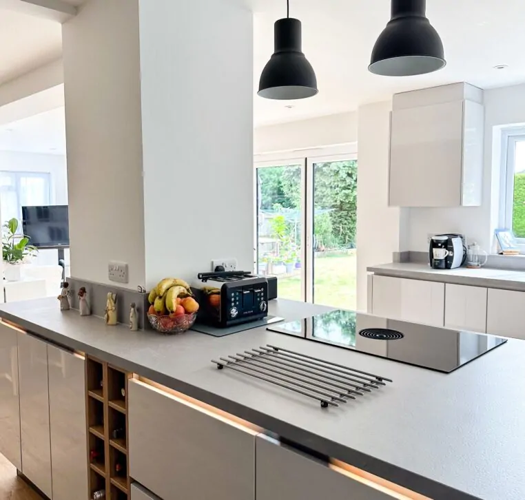 Close-up of a modern kitchen island featuring a sleek induction hob and black toaster