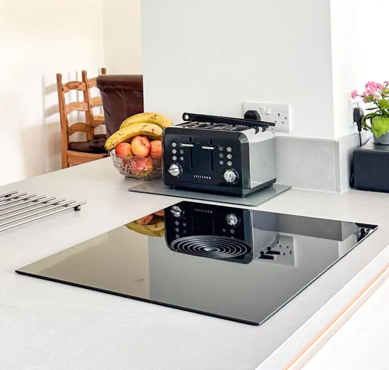 Kitchen island with a built-in wine rack, fruit bowl, and integrated appliances