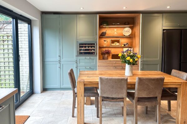 Spacious light U-shaped wood shaker kitchen featuring a built-in wine cooler and display shelves