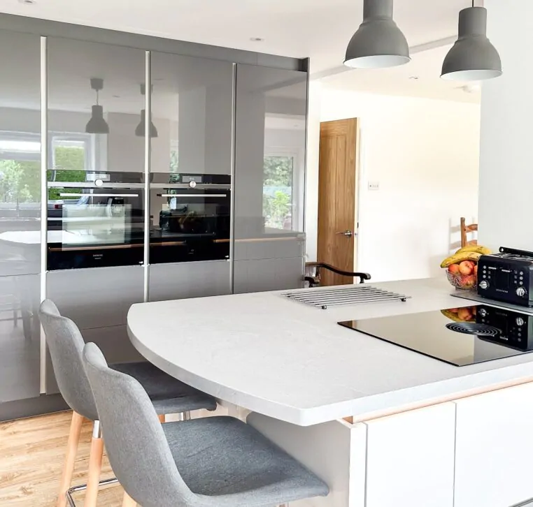 Open-plan kitchen featuring a modern island, wine rack, and high stools