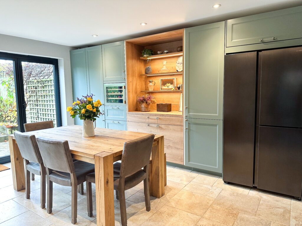 Modern wood shaker kitchen with a rustic wooden dining table and garden view