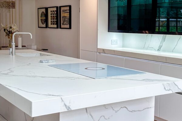 A modern kitchen with built-in high-end appliances, marble surfaces, and a sophisticated neutral color palette.