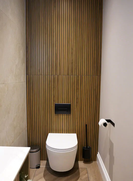 Bathroom WC set against a vertical slatted feature wall.