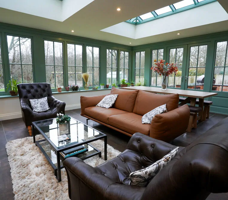 Contemporary living area with green framed windows and leather seating.