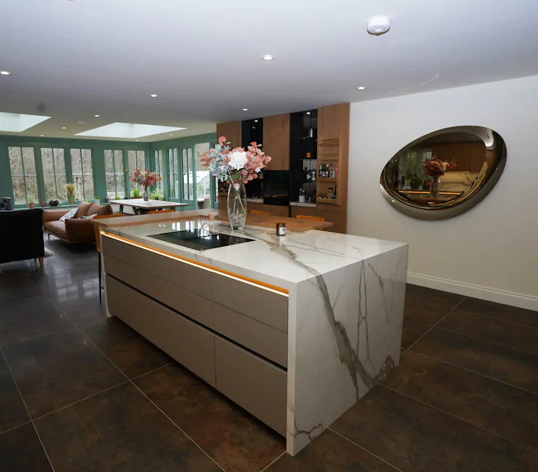 Open plan kitchen and living space with marble island and modern seating.