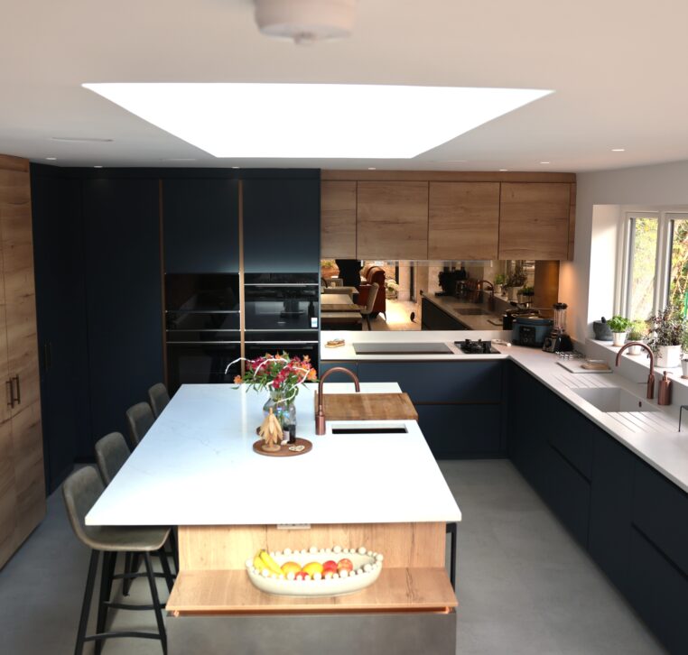Bespoke open plan kitchen with central island, skylight and dark blue and wood cabinetry