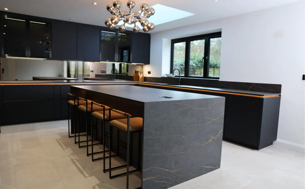 Kitchen island with breakfast bar seating, stone worktop and integrated LED lighting