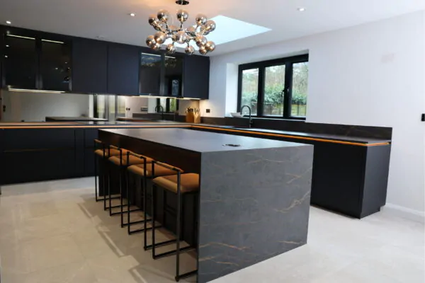Sleek Dark Matt Kitchen with Stone Waterfall Island, Breakfast Bar & Sliding Glass Doors