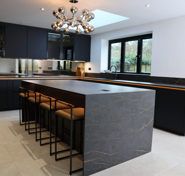 Kitchen island with breakfast bar seating, stone worktop and integrated LED lighting