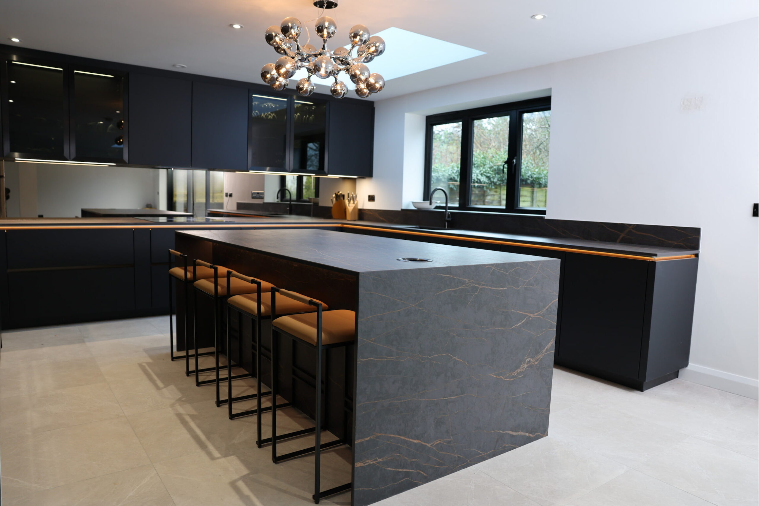 Kitchen island with breakfast bar seating, stone worktop and integrated LED lighting