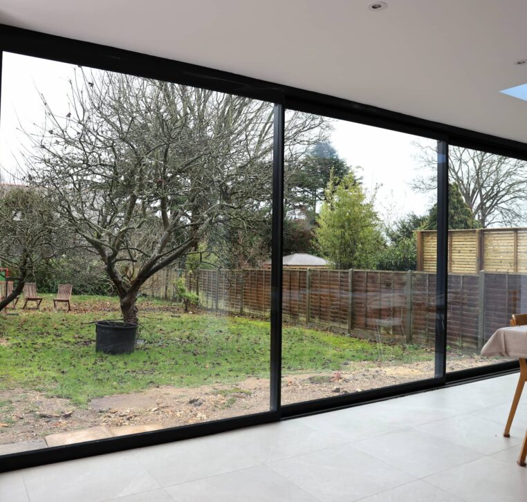 Open plan kitchen with large sliding glass doors opening out to garden