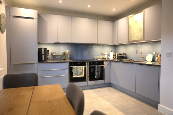 Modern Grey Handleless Kitchen with Stone Worktops & Glass Splashback