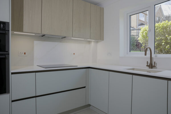 Contemporary Handleless Kitchen with White Quartz Worktops, Wood Accents & Integrated Lighting