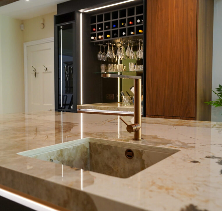 Kitchen with under-cabinet LED lighting highlighting bespoke cabinetry and work surfaces.