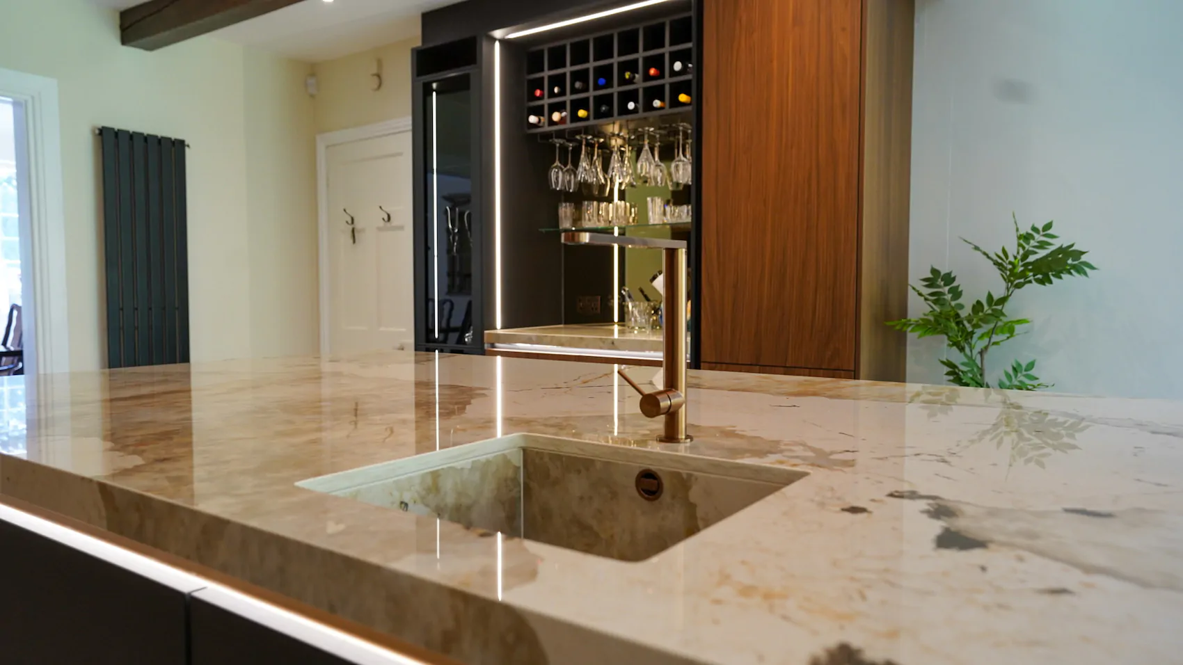 Kitchen with under-cabinet LED lighting highlighting bespoke cabinetry and work surfaces.
