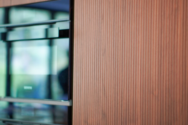 Modern kitchen showing wood cabinetry with integrated oven and appliance detailing, designed and installed by MAS Kuchen.