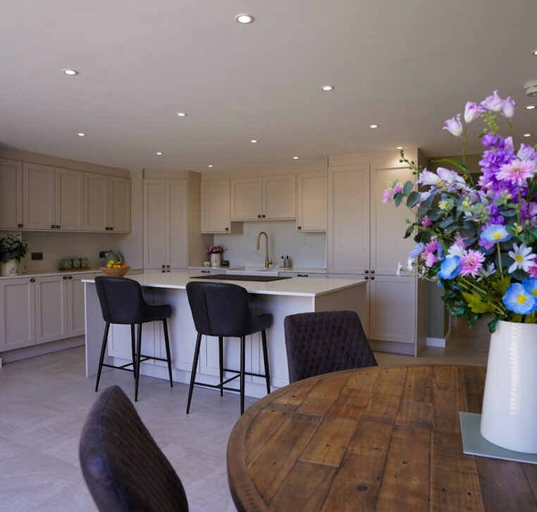 Open-plan family kitchen with shaker cabinetry, central island and dining area designed by MAS Kuchen.