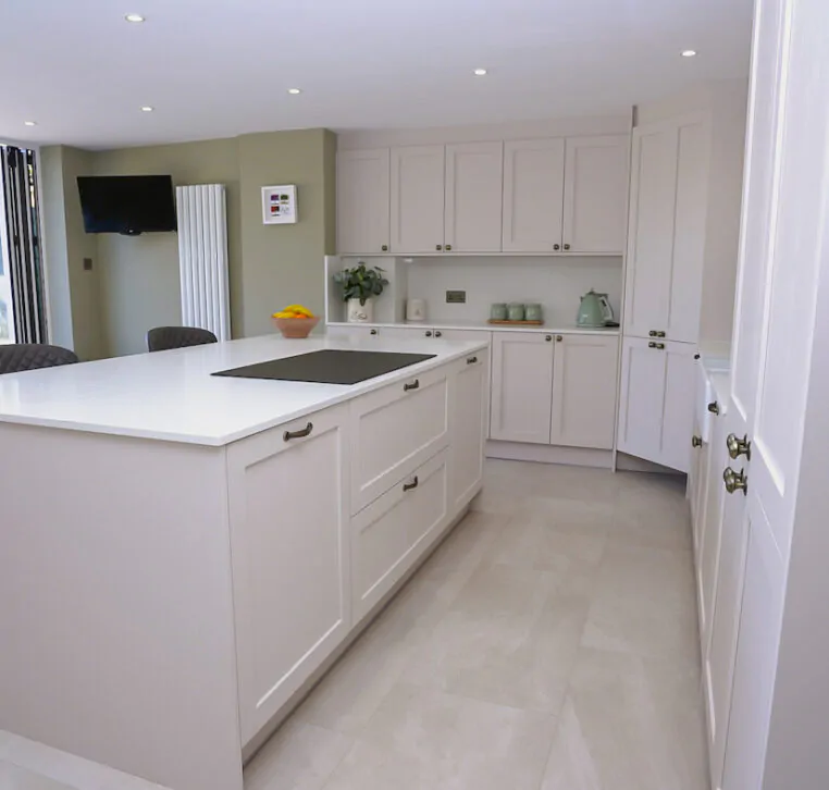 Open-plan shaker kitchen with large island and bifold doors creating a bright family living space.